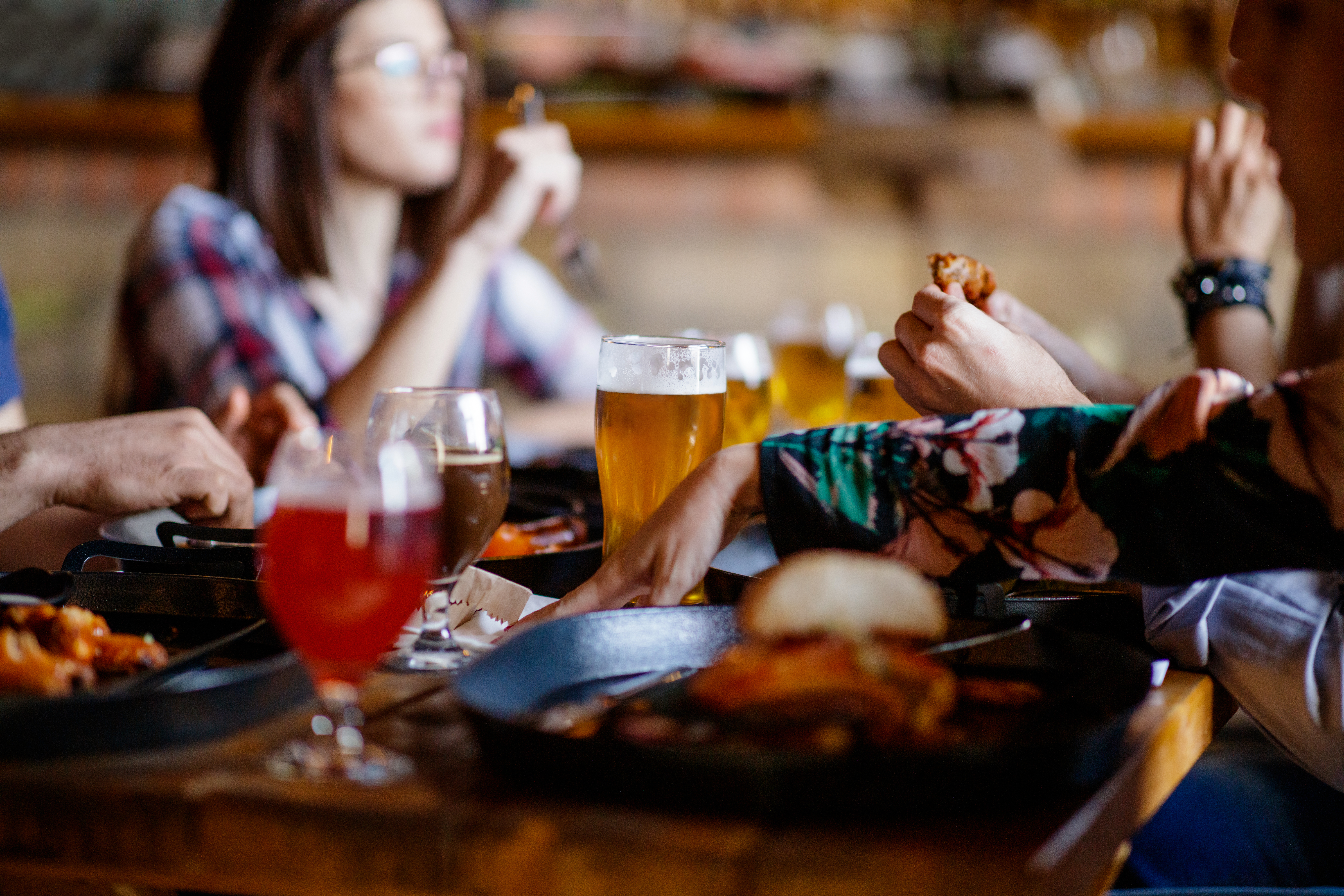 Having dinner and craft beer, sitting at the table in a pub with friends