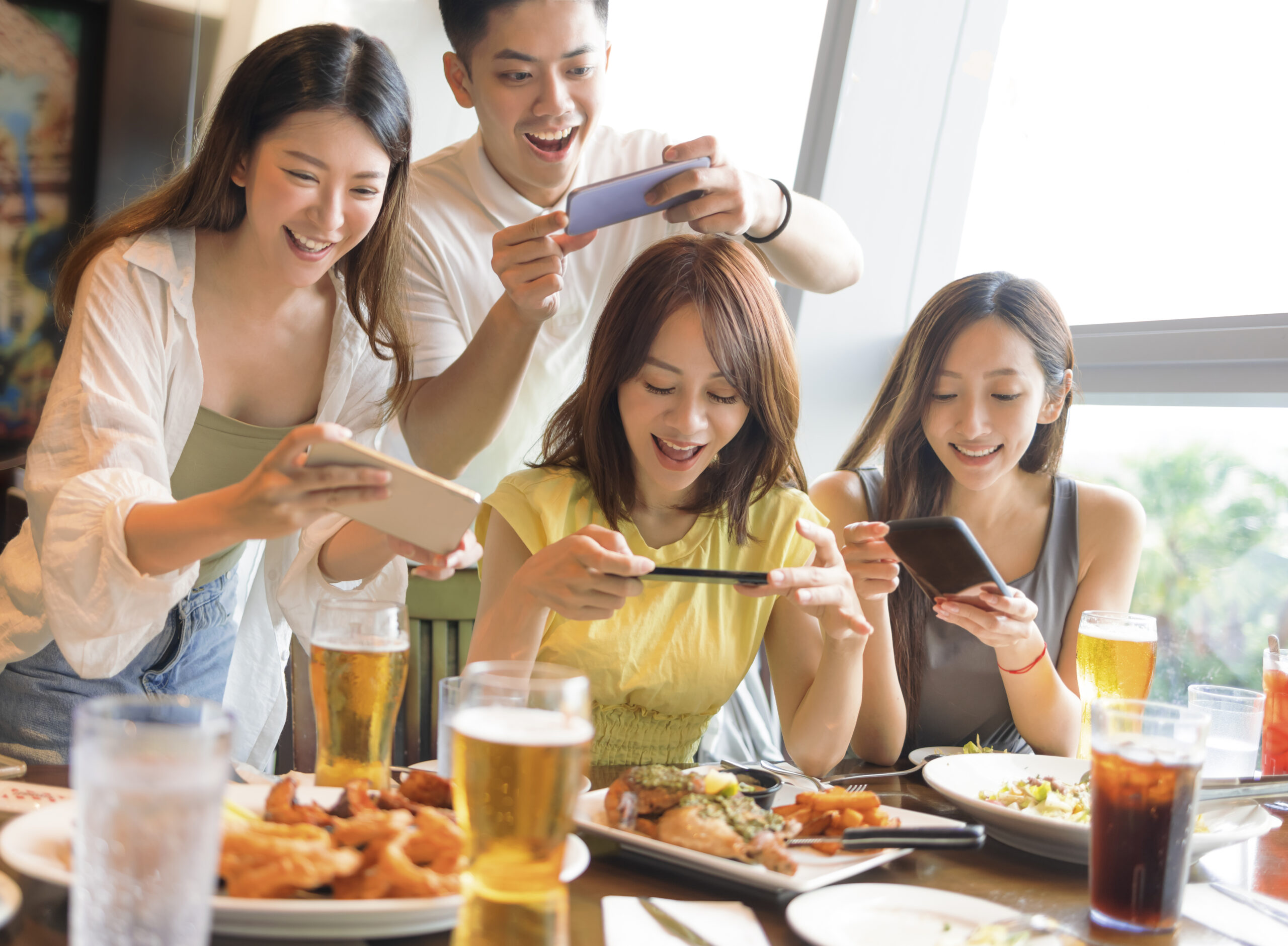 Happy young group taking  picture with smart phone before dinner